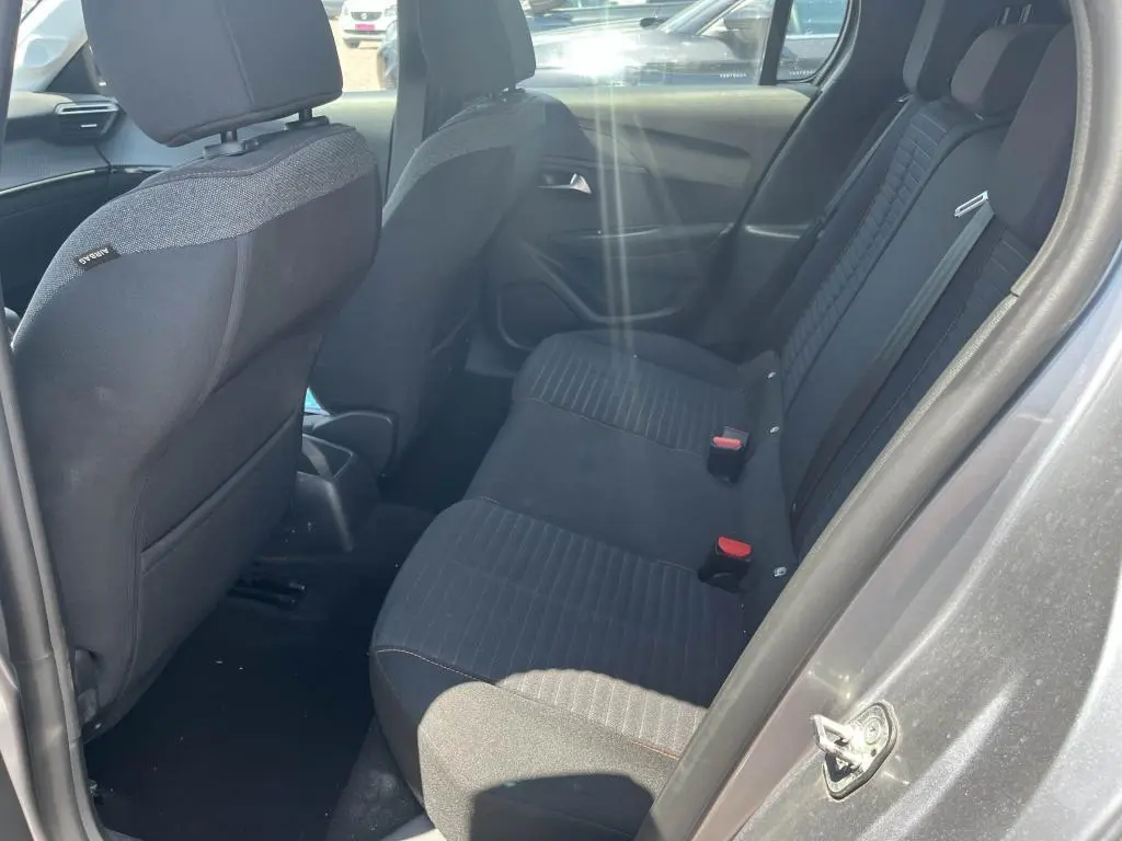 Vue intérieure côté droit montrant la banquette arrière noire de la Peugeot 208 gris clair 2023.