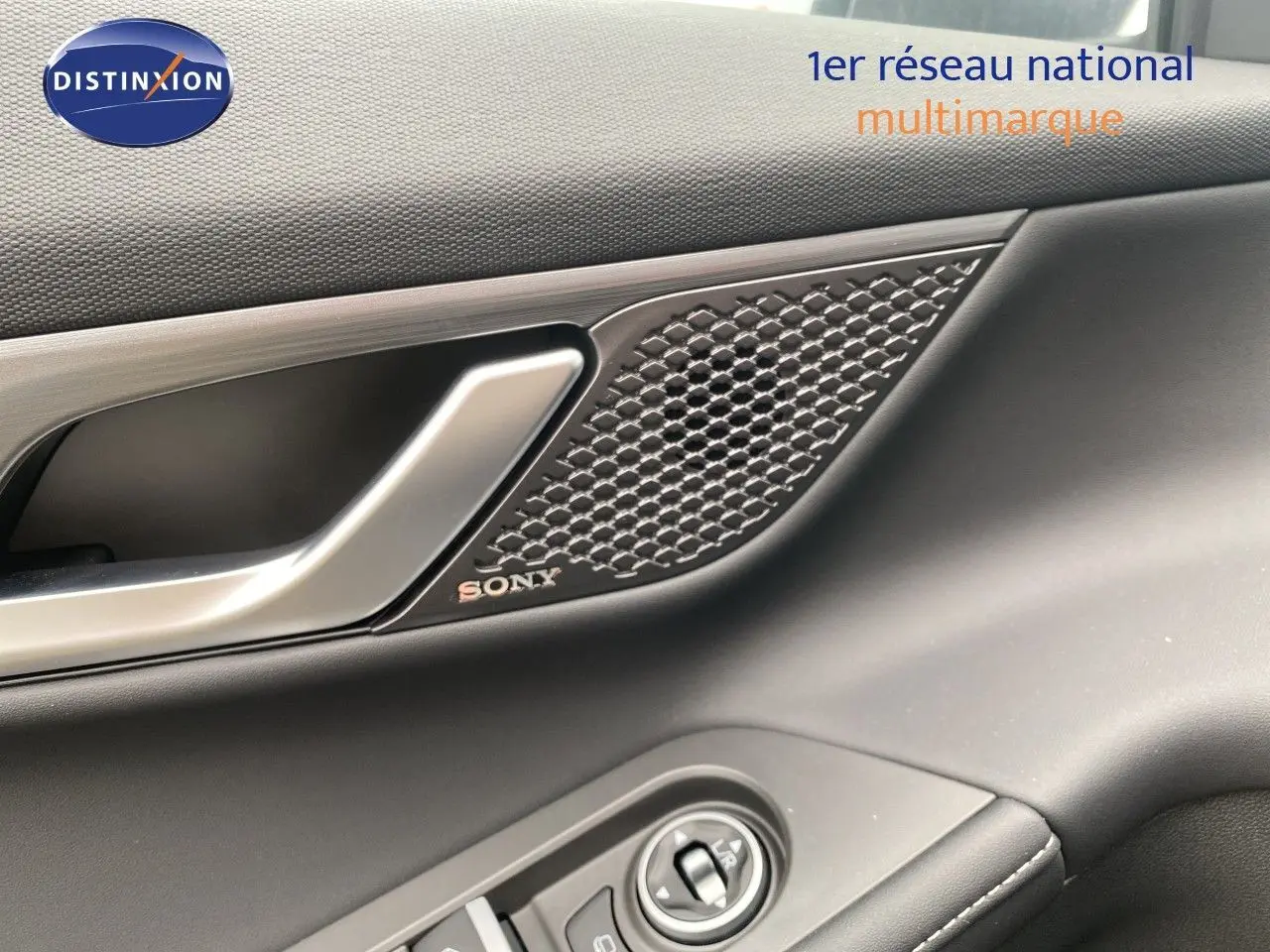 Détail de la porte côté conducteur du JAECOO J5 gris Phantom, avec poignée argentée et haut-parleur Sony intégré.