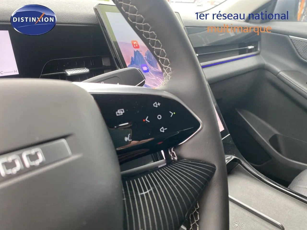 Vue rapprochée du volant cuir noir avec commandes tactiles et partie de la planche de bord intérieure grise du JAECOO J5.