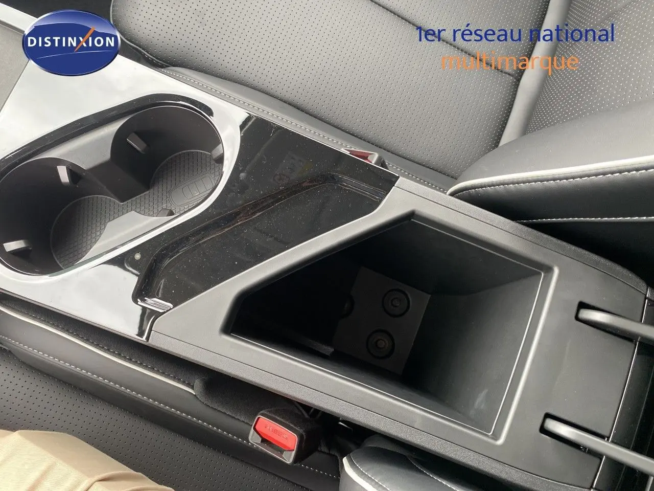 Gros plan sur la console centrale noire avec porte-gobelets et rangement, intérieur cuir noir du JAECOO J5.