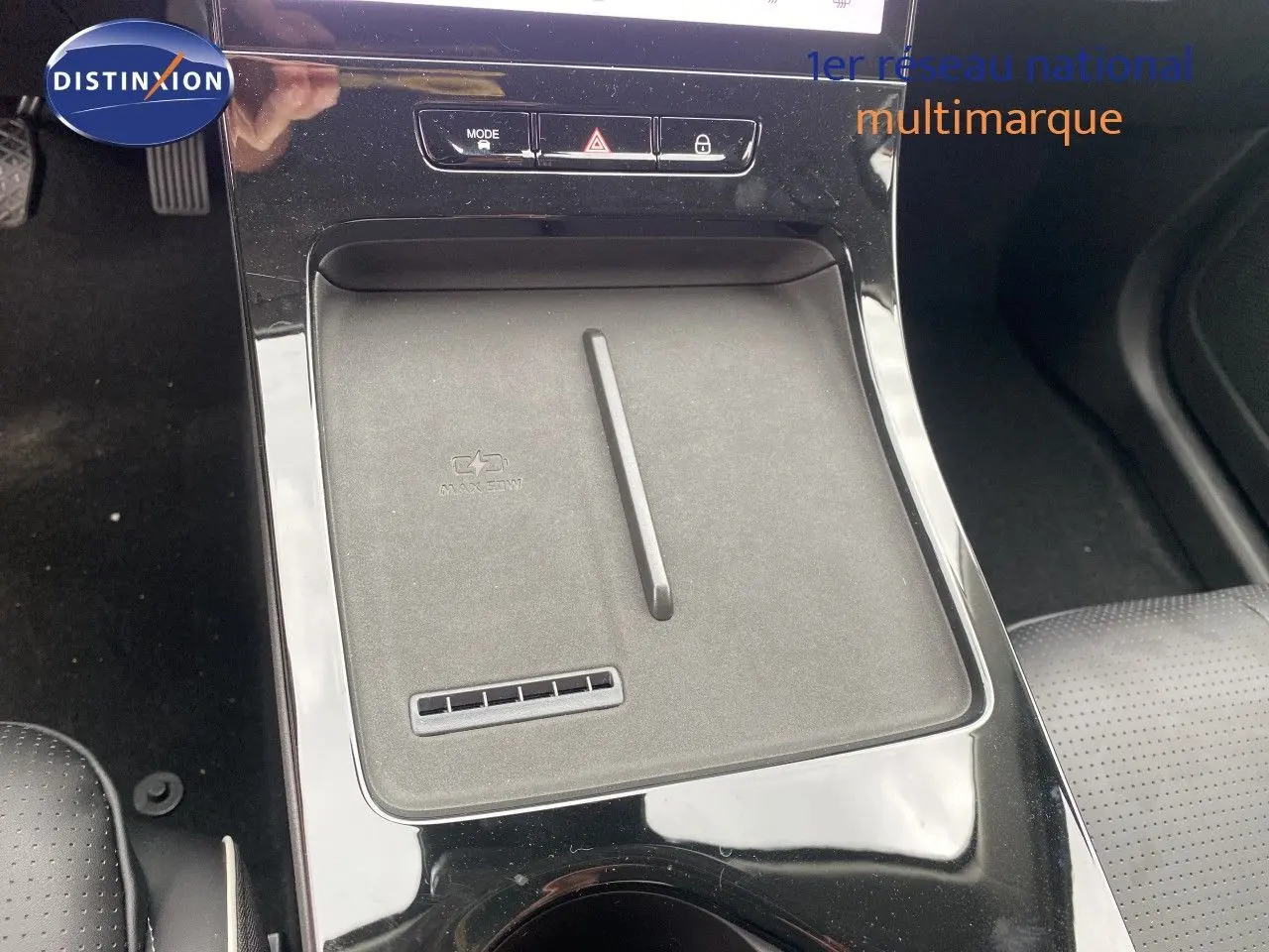 Vue rapprochée de la console centrale du JAECOO J5 1.5 TGDI HEV 165CH BVA en Phantom Grey, avec surface de recharge sans fil.