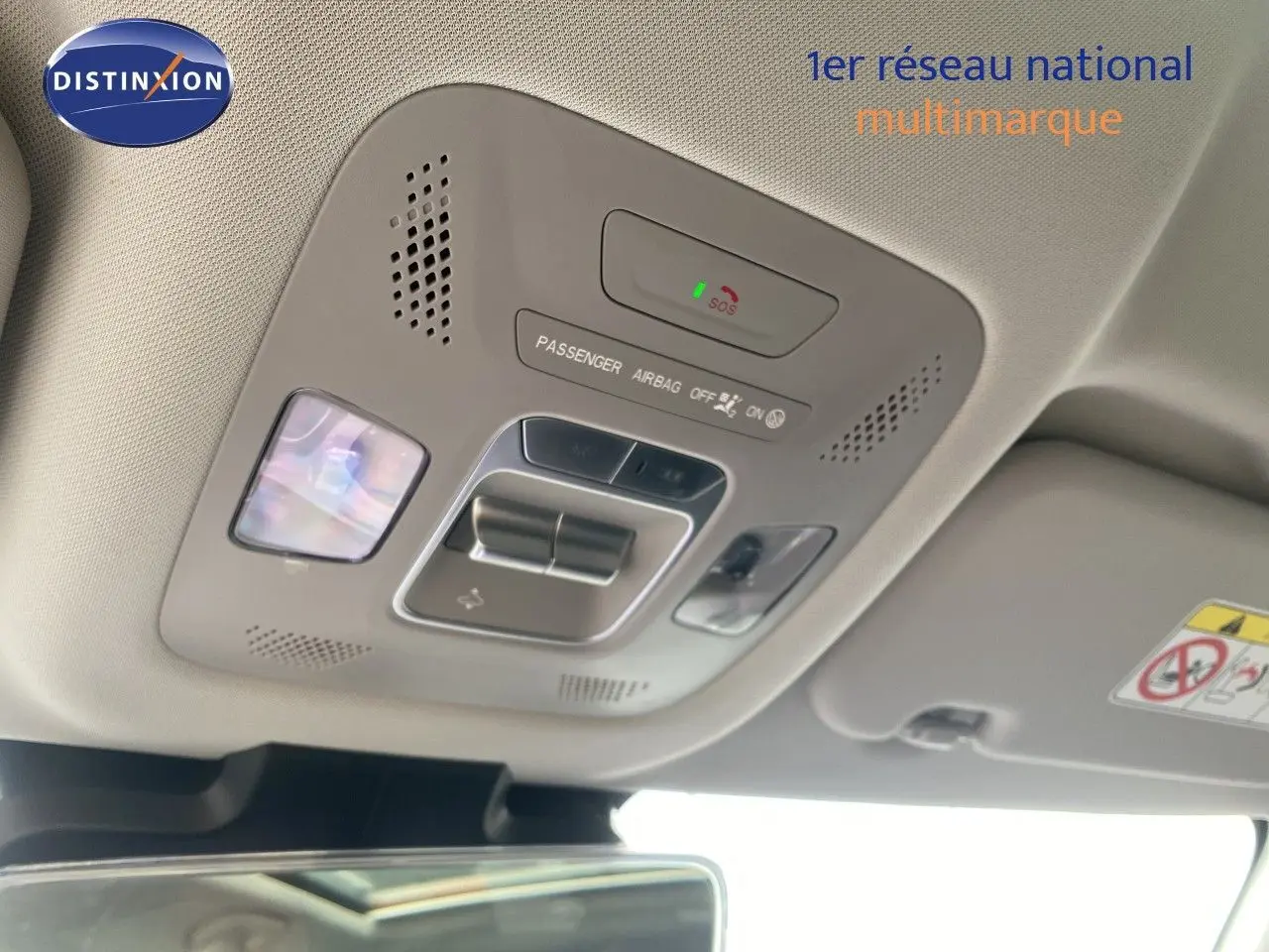 Plafonnier intérieur gris clair avec commandes d’éclairage et indicateur airbag, vue en légère contre-plongée.