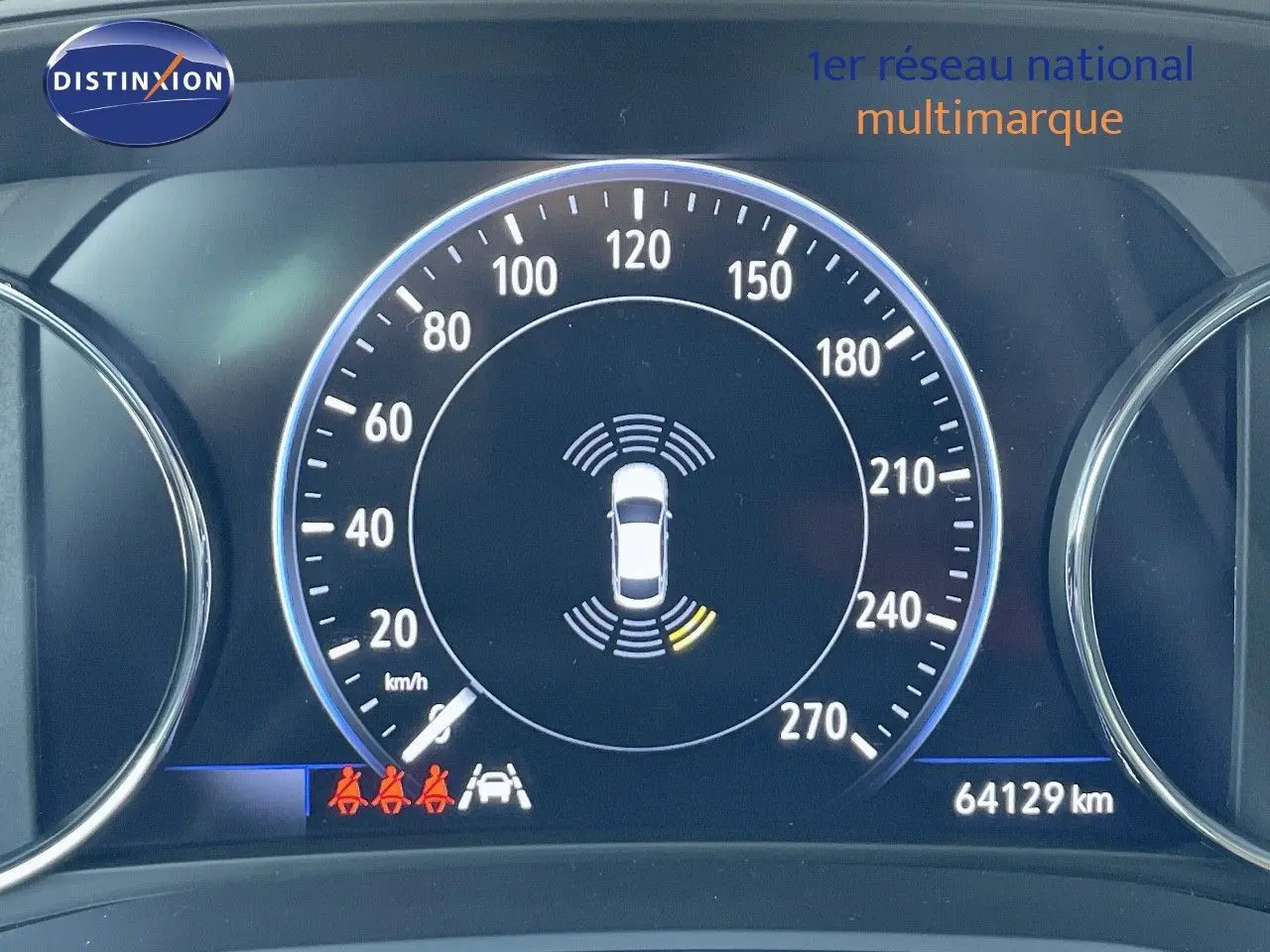 Gros plan sur le tableau de bord numérique de l'Opel Insignia 2.0D gris minéral, affichant la vitesse et les alertes de sécurité.