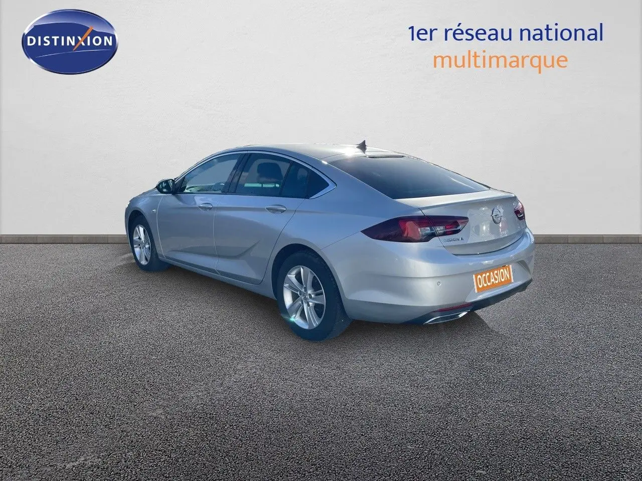 Opel Insignia gris minéral métal vue 3/4 arrière droit, berline 5 portes avec jantes alliage et feux LED.