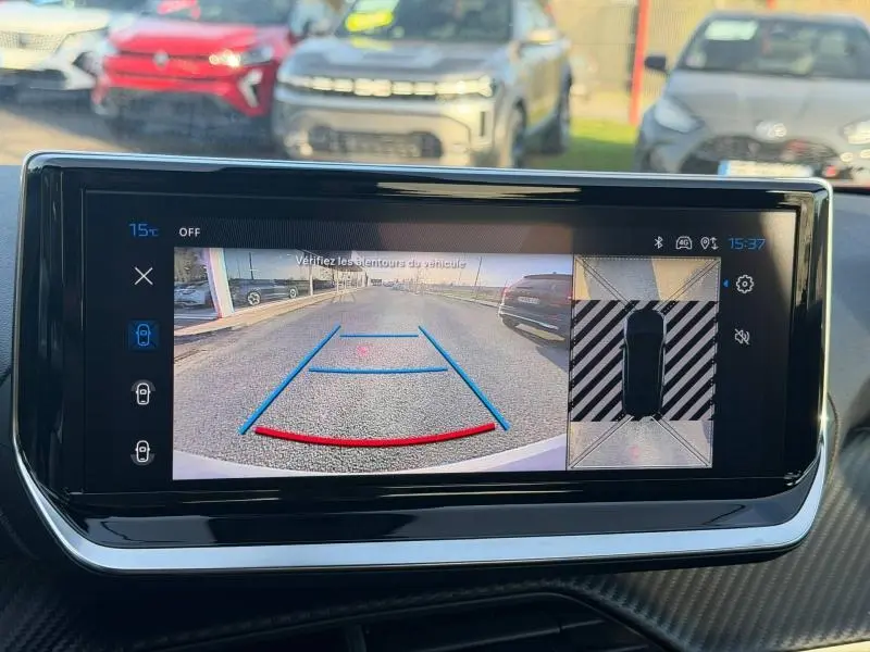Vue de la caméra de recul sur écran tactile intérieur du Peugeot 2008 rouge Elixir, affichant l’aide au stationnement.