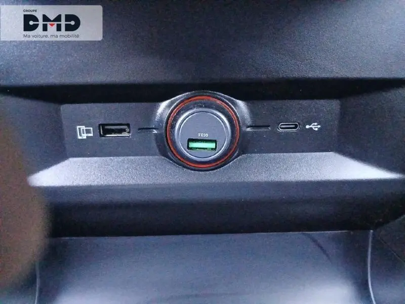 Gros plan sur la console centrale du MG4 EV 2023 montrant les ports USB et prise 12V avec cercle orange lumineux.