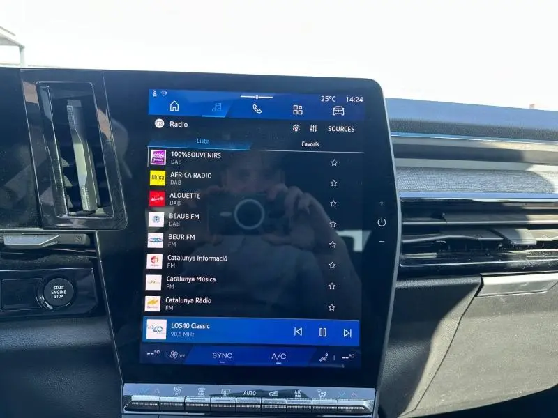 Vue rapprochée de l’écran tactile central du Renault Austral 2025 Bleu Iron, affichant la liste des radios DAB.