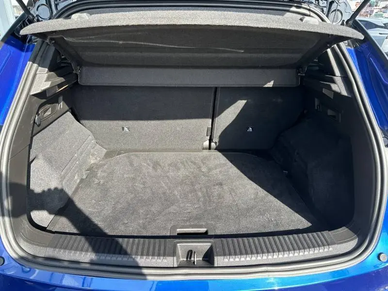 Coffre ouvert vu de l'arrière d'un Renault Austral Bleu Iron 2025, montrant un espace de chargement propre et spacieux.