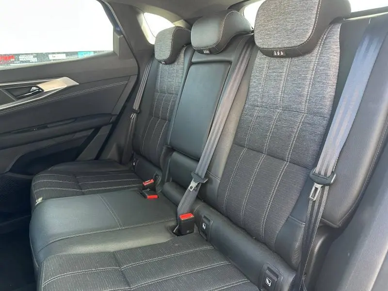 Vue intérieure des sièges arrière du Renault Austral 2025, tissu noir avec surpiqûres et ceintures de sécurité grises.