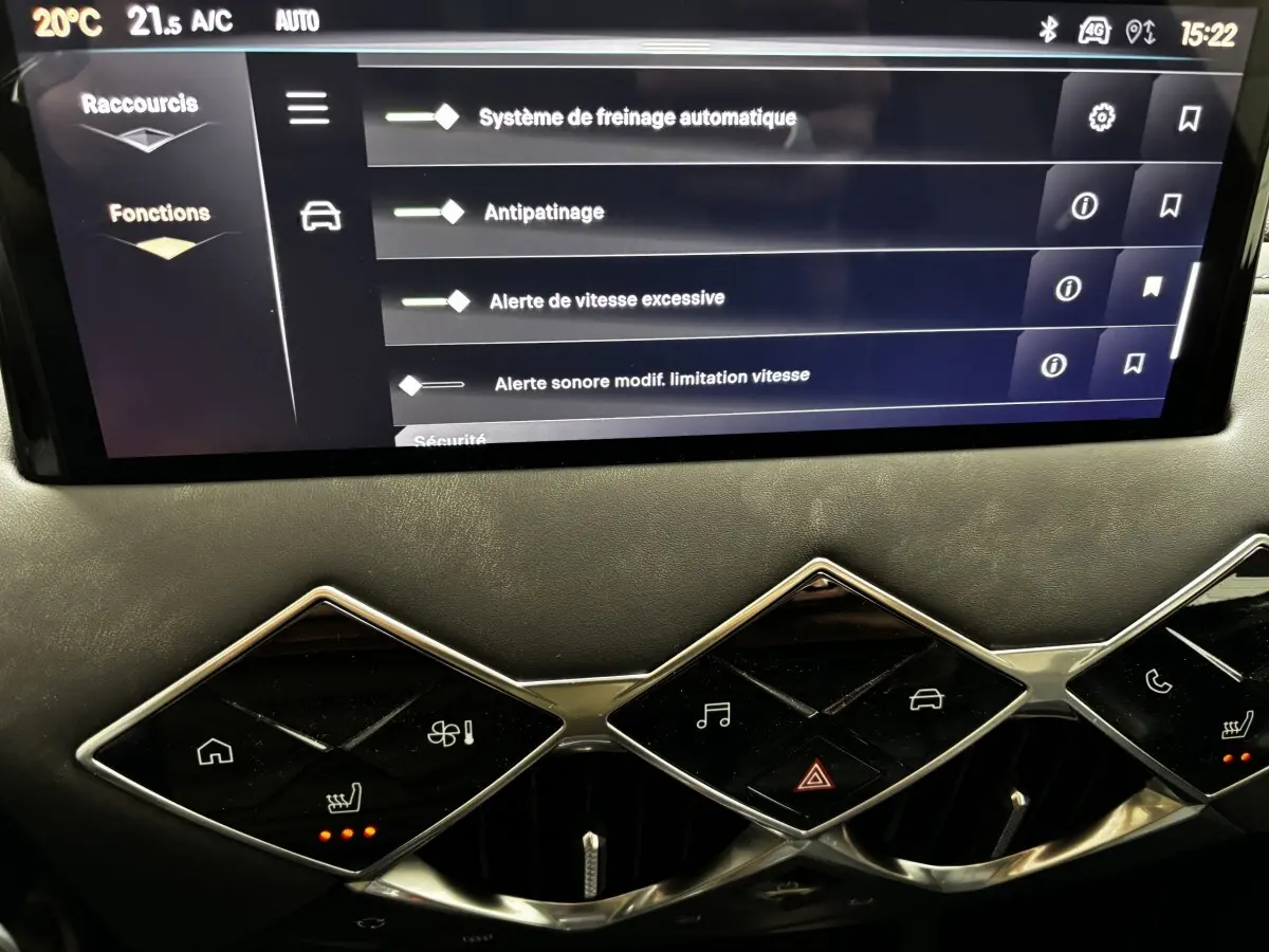 Vue rapprochée de l’écran tactile et des commandes en losange du tableau de bord du DS3 gris clair 2024.