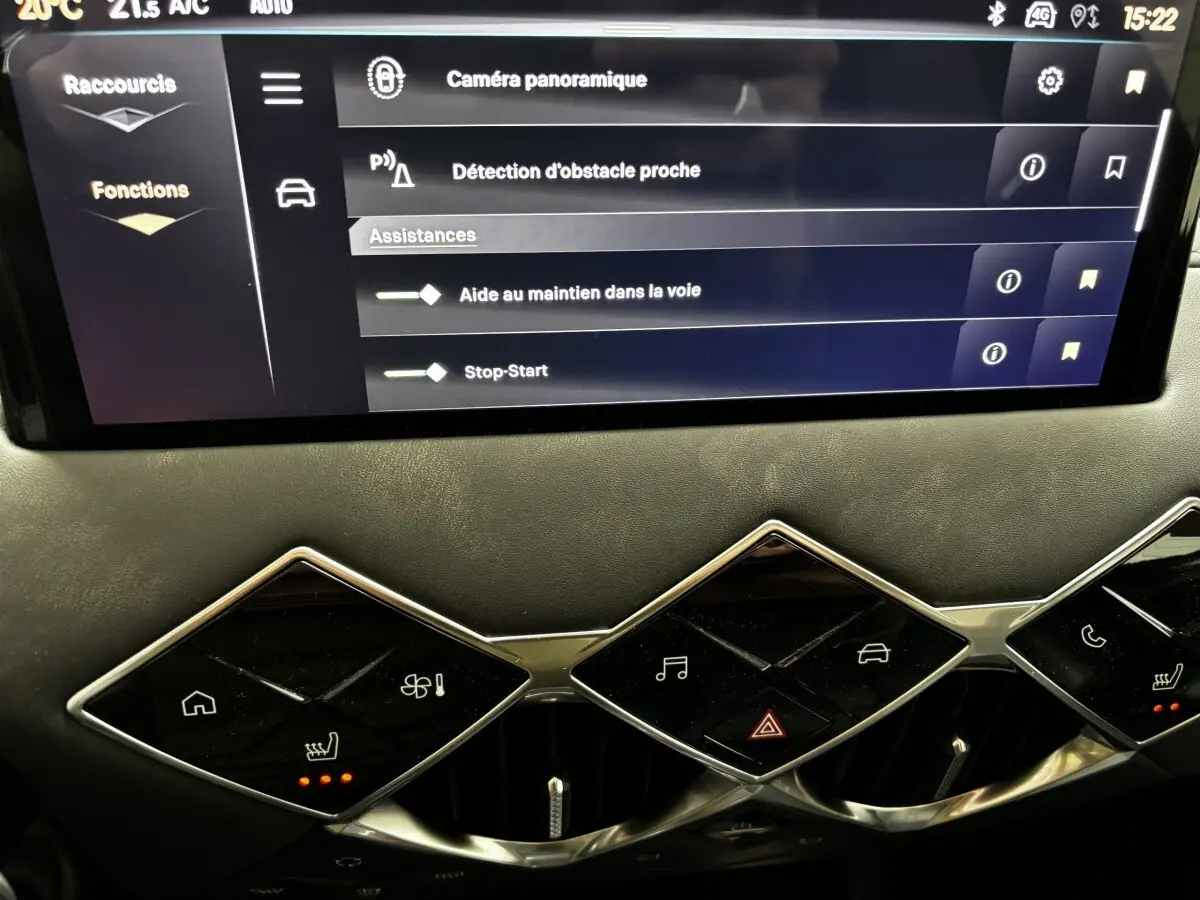 Gros plan sur la console centrale tactile et les commandes en losange du tableau de bord intérieur du DS3 gris clair 2024.