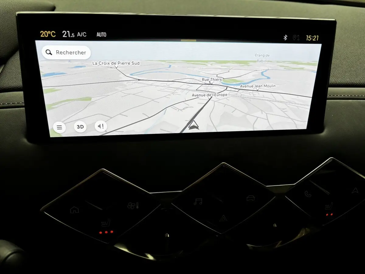 Écran tactile central du tableau de bord du DS3 2024 affichant la navigation 3D avec carte et commandes tactiles en dessous.