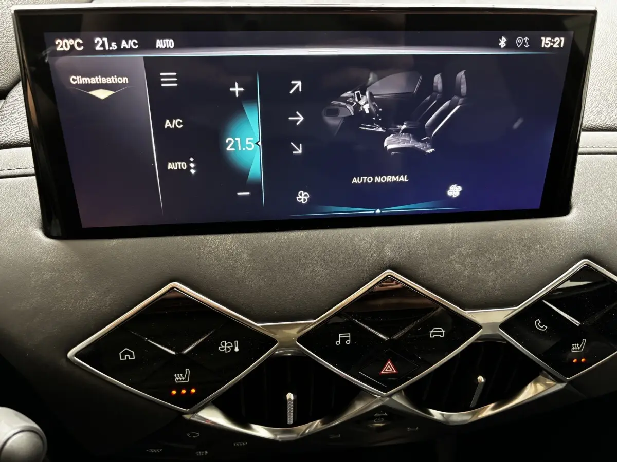 Gros plan sur l'écran tactile central et les commandes de climatisation du tableau de bord du DS3 gris clair 2024.