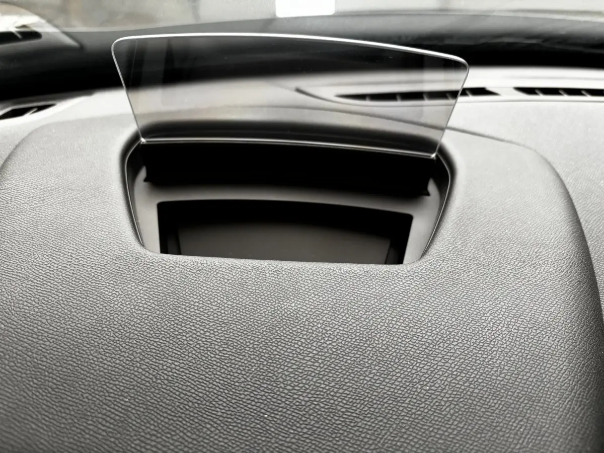 Vue rapprochée du tableau de bord gris foncé du DS3 2024 avec écran tête haute transparent déployé.