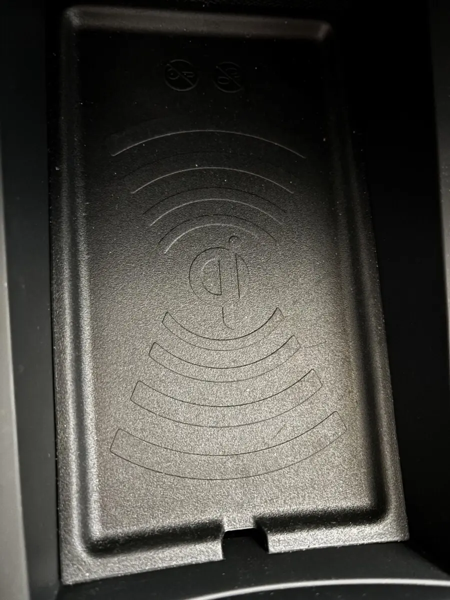 Gros plan sur la zone de recharge par induction noire dans l'habitacle de la DS3 gris clair 2024.