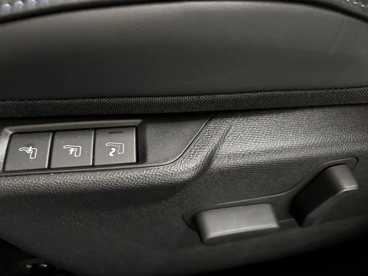 Gros plan sur les commandes de réglage des sièges en plastique noir à l'intérieur d'une DS3 gris clair.