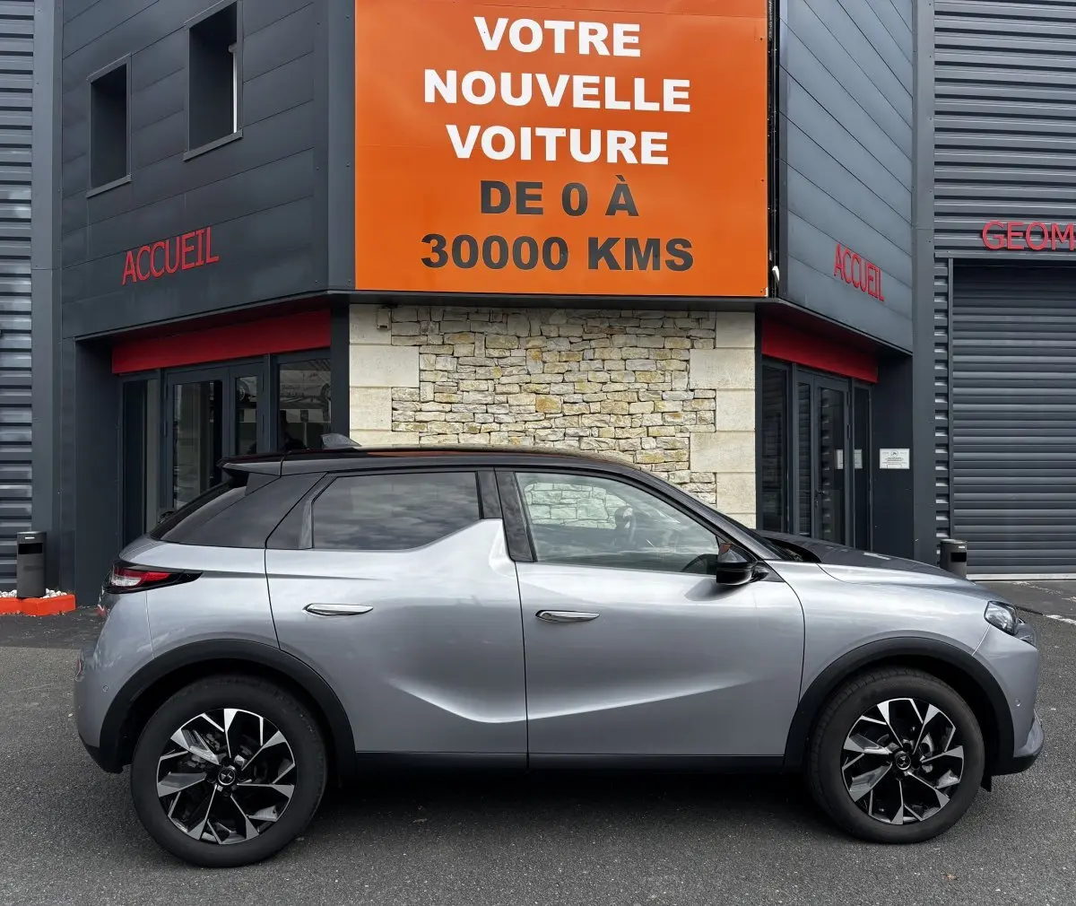 Vue de profil côté gauche d'une DS3 2024 gris clair avec toit noir et jantes alliage noires et argentées.