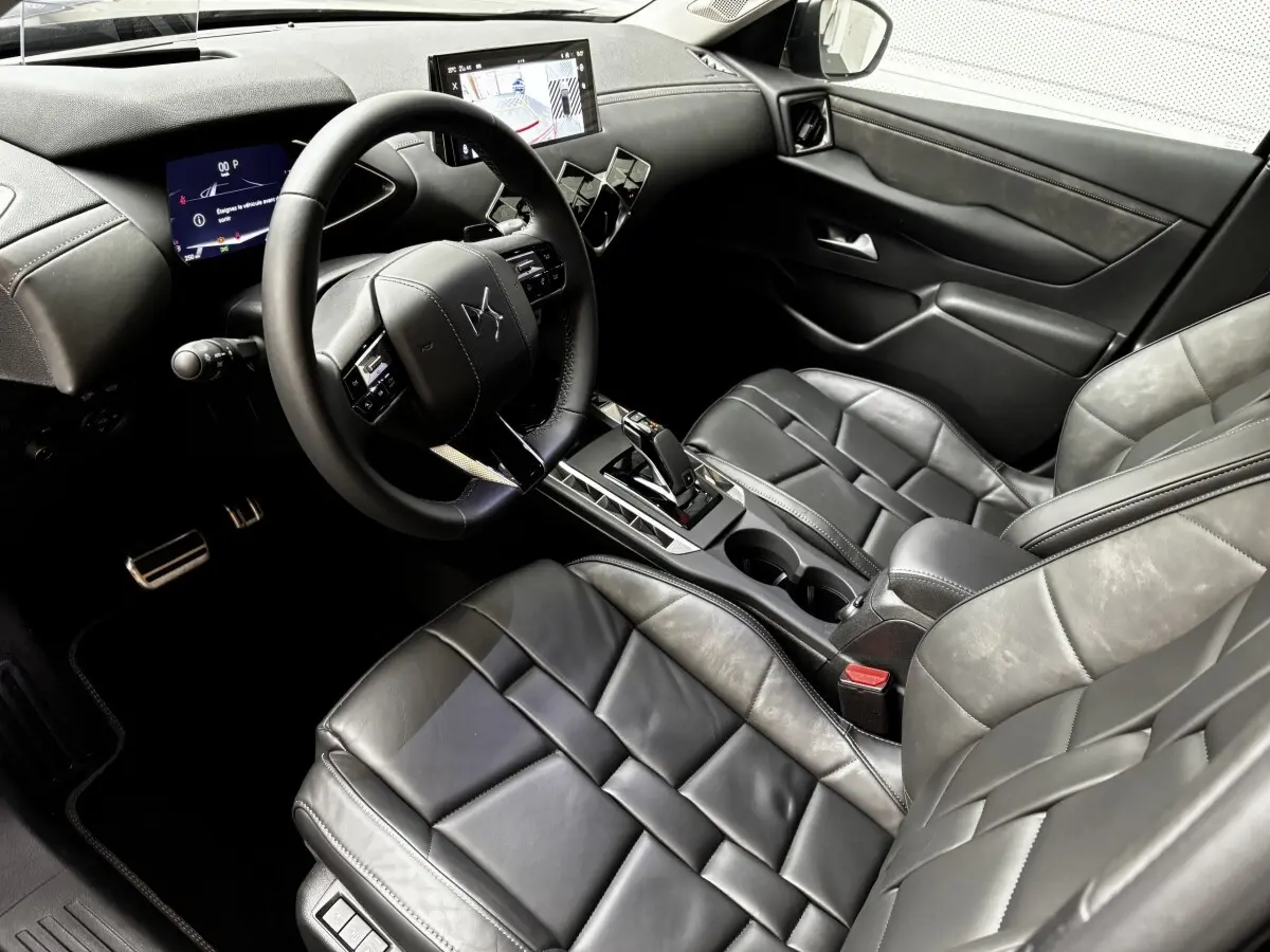Vue intérieure côté conducteur du DS3 2024 avec sièges cuir noirs, volant multifonctions et écran tactile central.