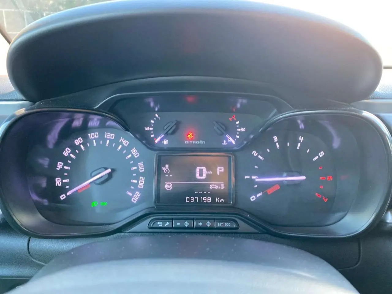 Vue rapprochée du tableau de bord numérique d'une Citroën C3 2023, affichant la vitesse à 0 km/h et le compteur à 37 198 km.