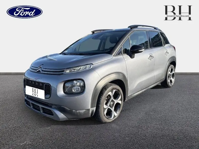 Citroën C3 Aircross gris acier vue 3/4 avant droit avec barres de toit et jantes diamantées 17 pouces.