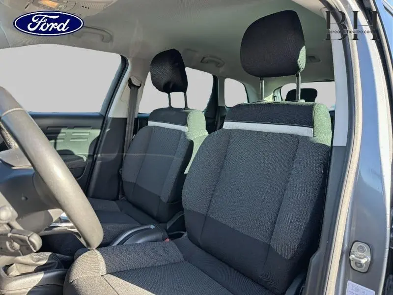 Vue intérieure côté conducteur montrant les sièges en tissu Mica Grey d'une Citroën C3 Aircross gris acier.