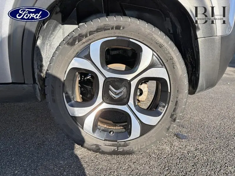 Gros plan sur la roue avant droite d'une Citroën C3 Aircross gris acier avec jante diamantée 17 pouces.