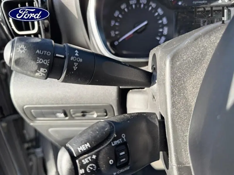 Gros plan sur les commandes au volant noir du tableau de bord d'une Citroën C3 Aircross gris acier, angle latéral droit.