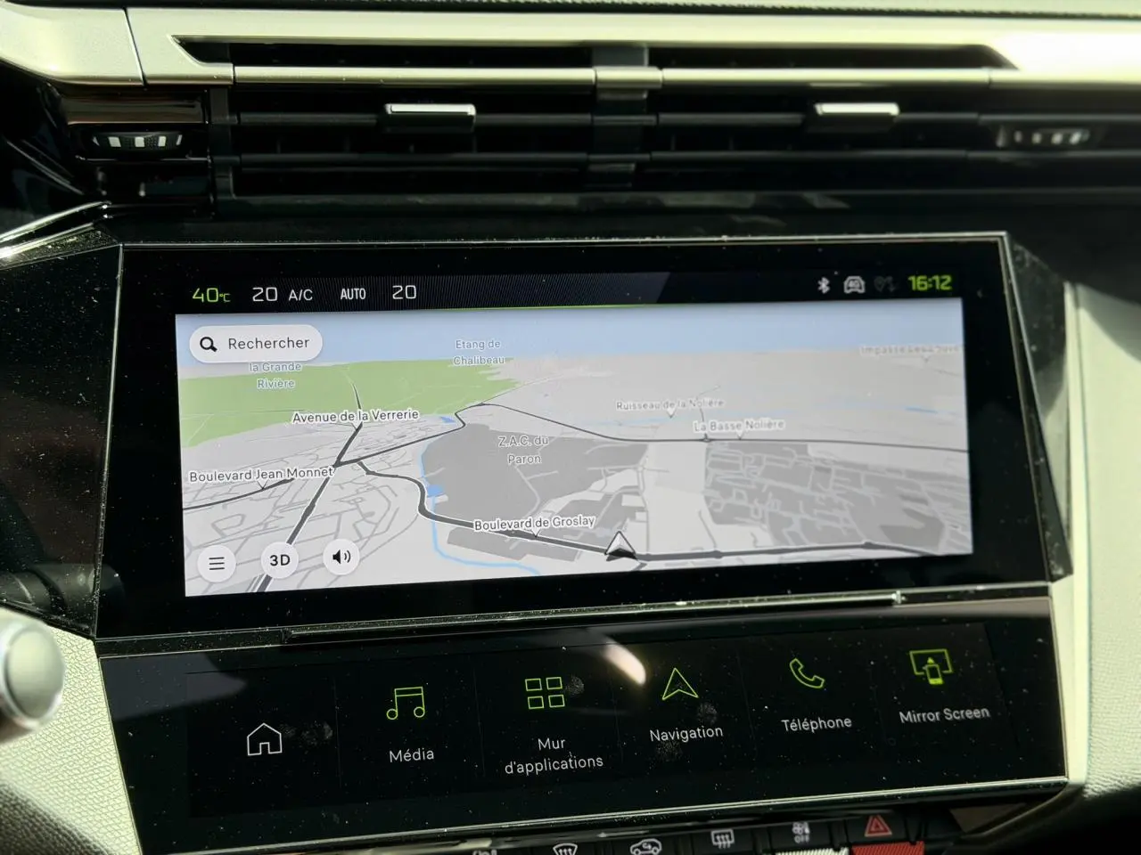 Écran tactile central du tableau de bord de la Peugeot 308 GT hybride, affichant la navigation en mode jour.