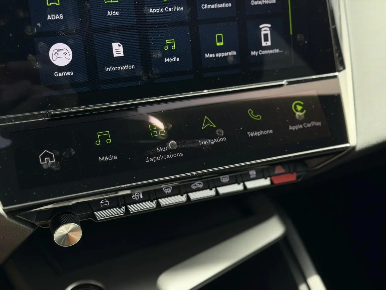 Vue rapprochée de la console centrale tactile de la Peugeot 308 Hybrid 2026, avec commandes multimédia et climatisation.