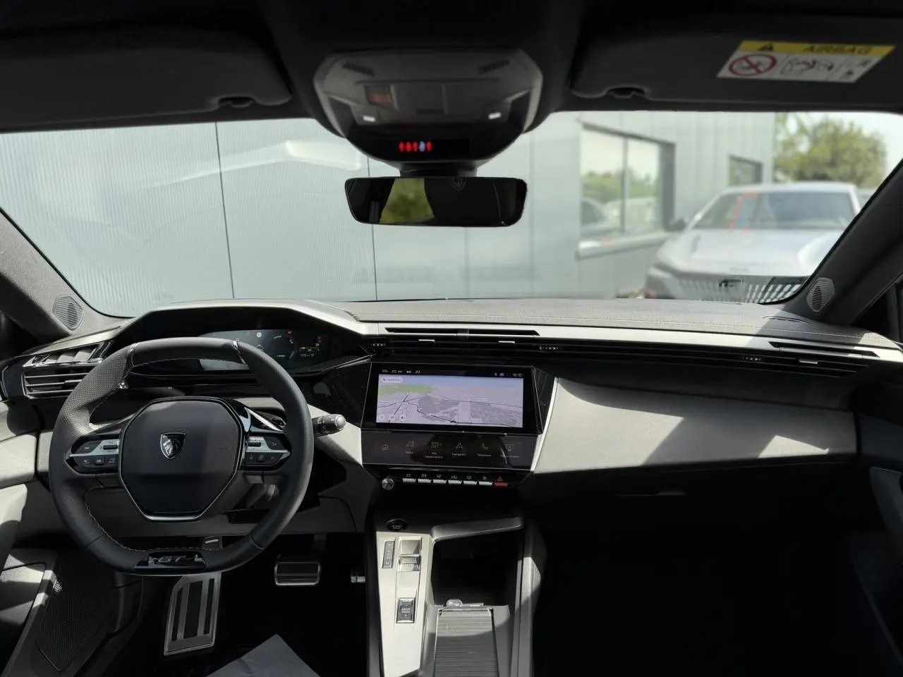 Vue intérieure avant du Peugeot 308 NV Hybrid 145 GT e-DSC6 avec tableau de bord numérique et écran tactile central.