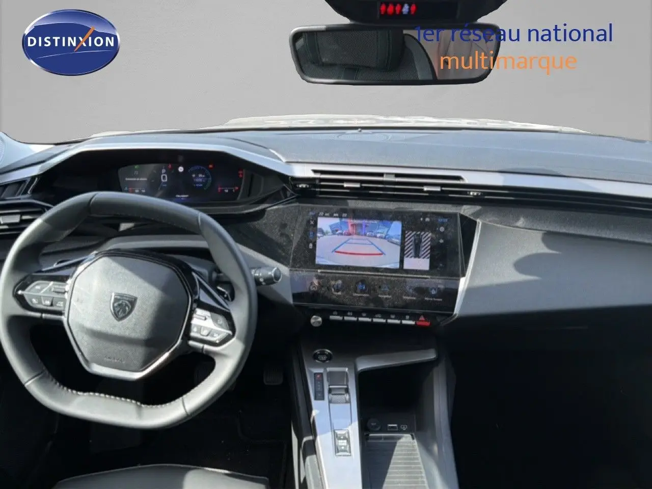 Vue intérieure du tableau de bord et volant de la Peugeot 308 Allure Hybrid 2025 en gris Selenium Metal, écran tactile avec caméra de recul.