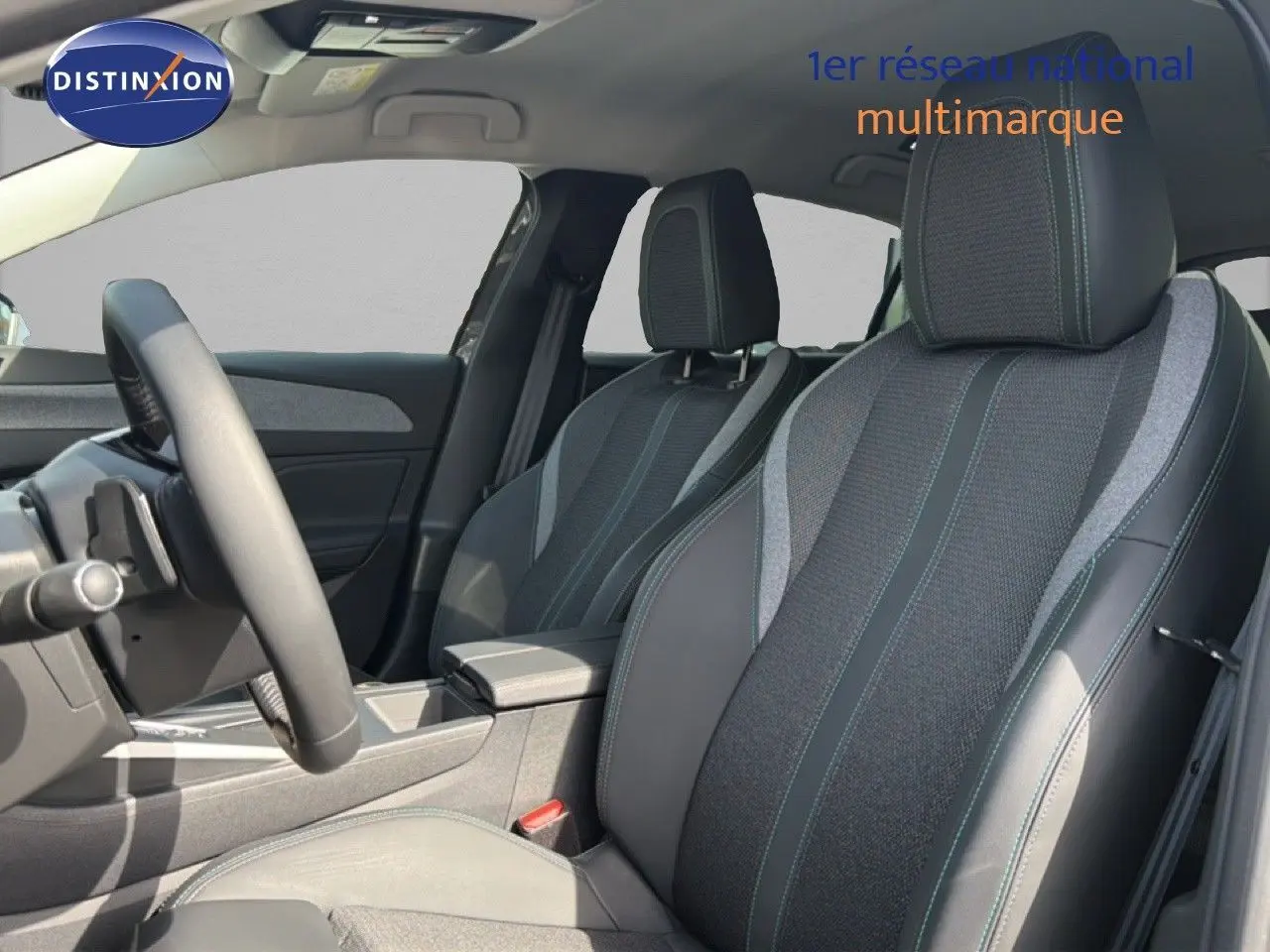 Vue intérieure côté conducteur de la Peugeot 308 Allure Hybrid 145 e-DCS6, sièges tissu et cuir gris avec surpiqûres bleues.