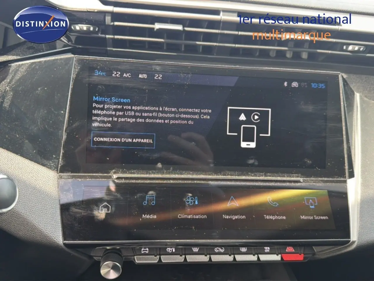 Vue rapprochée de l’écran tactile central du tableau de bord de la Peugeot 308 Allure Hybrid 2025, affichant les options multimédia et climatisation.