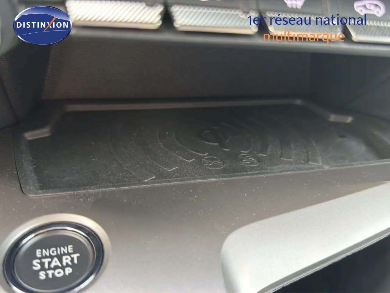 Gros plan sur la zone de recharge sans fil et le bouton start/stop dans l’habitacle d’une Peugeot 308 gris Selenium.