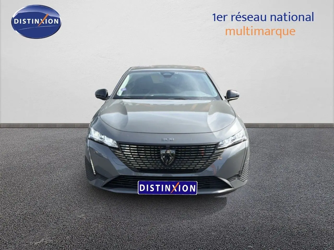 Vue frontale d'une Peugeot 308 Allure Hybrid 145 e-DCS6 gris selenium metal, avec calandre noire et phares LED fins.