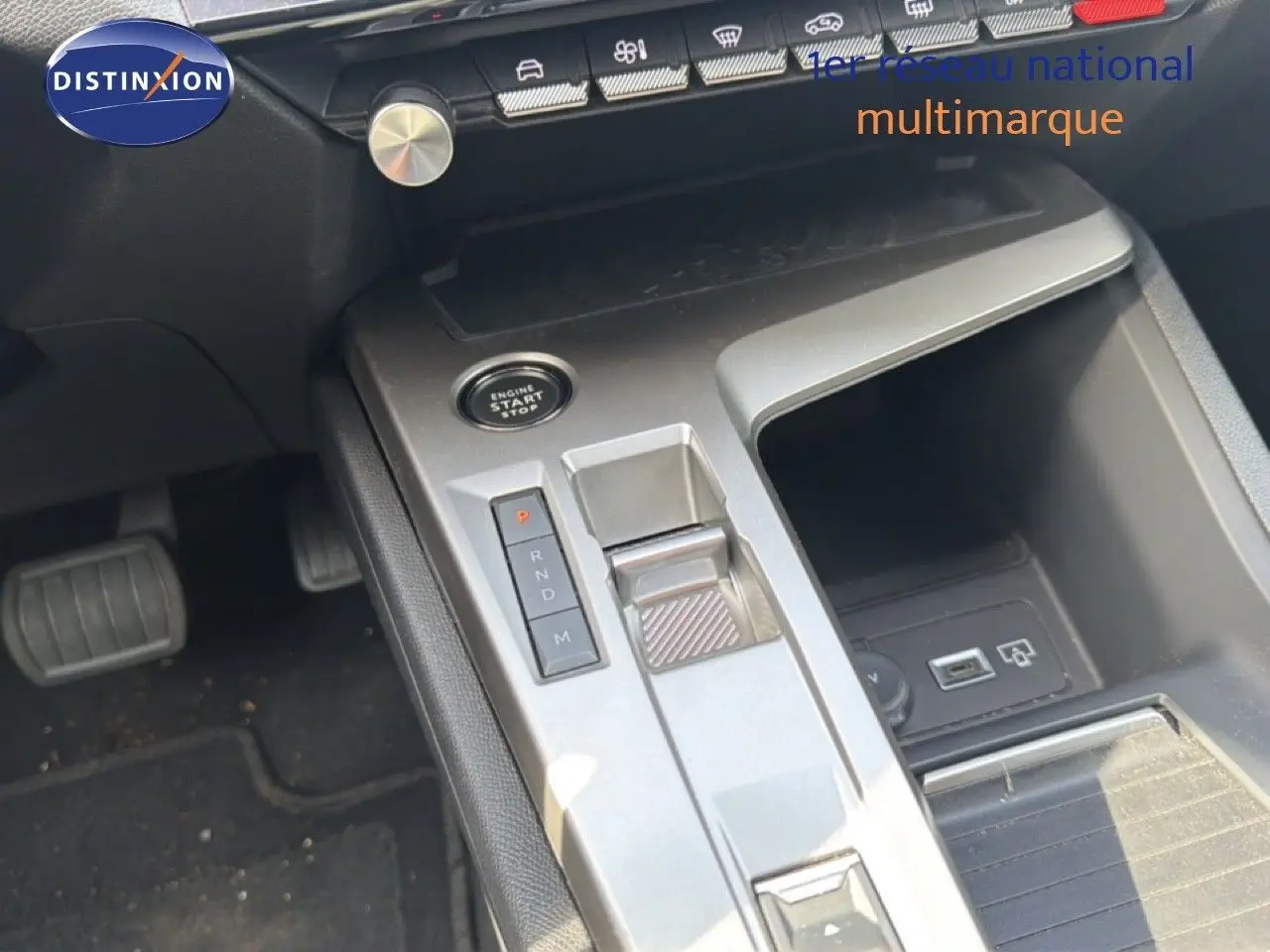 Vue rapprochée de la console centrale de la Peugeot 308 Allure Hybrid 2025, avec levier de vitesses automatique et bouton start/stop.
