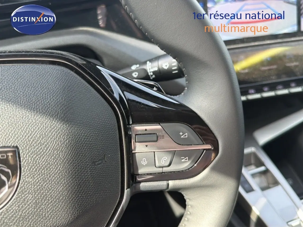 Gros plan sur le volant cuir de la Peugeot 308 Allure Hybrid 2025 avec commandes audio et téléphone intégrées.