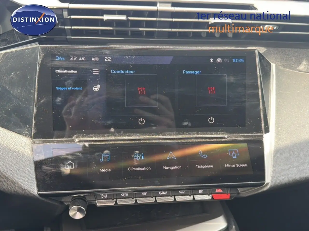 Écran tactile central du tableau de bord du Peugeot 308 Allure Hybrid 145 e-DCS6, affichant la climatisation et les options multimédia.