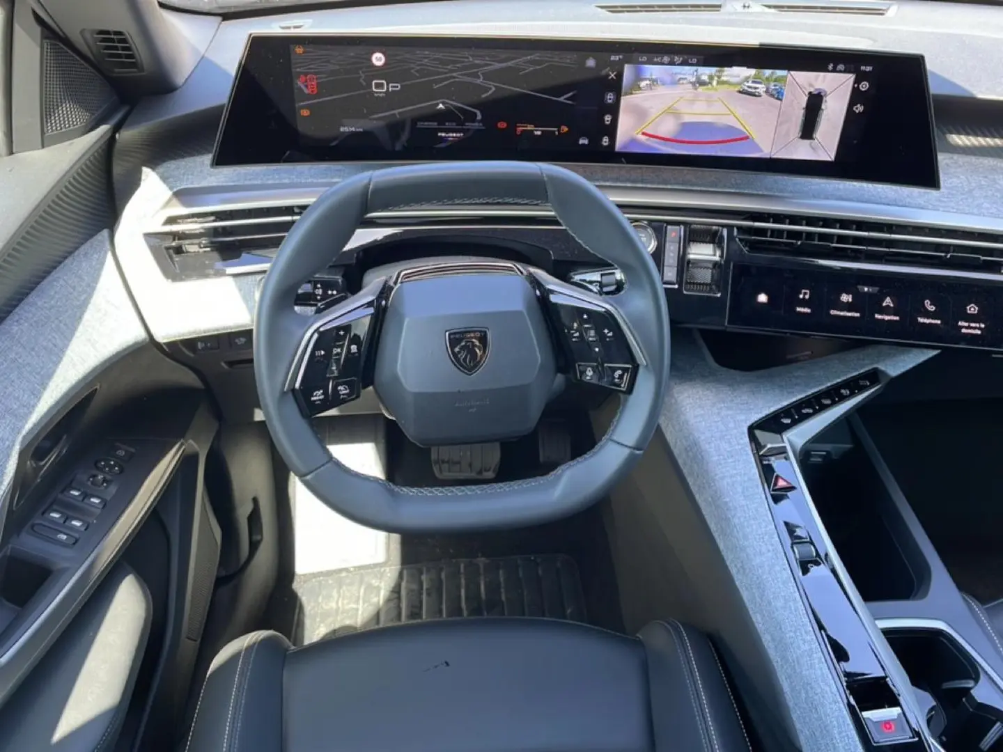 Vue intérieure du tableau de bord du Peugeot 5008 Hybrid 145 allure e-dcs6 2025 avec volant cuir et écrans numériques larges.