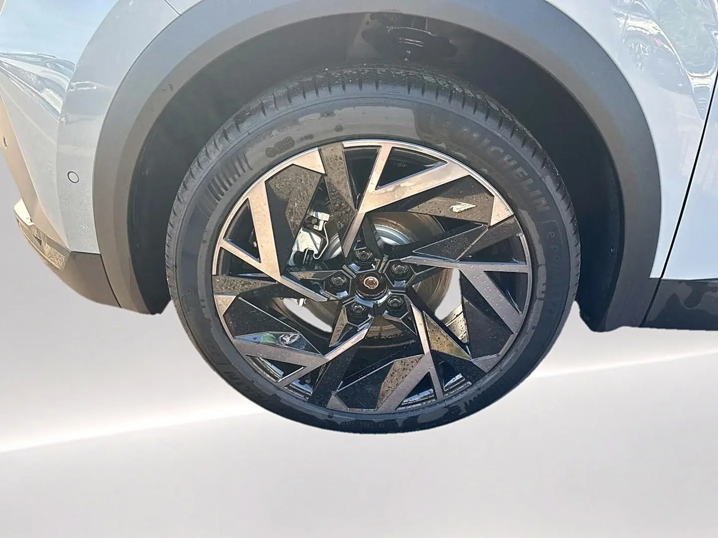 Gros plan sur la roue avant gauche du Renault Symbioz gris rafale, jante alu au design géométrique noir et argent.
