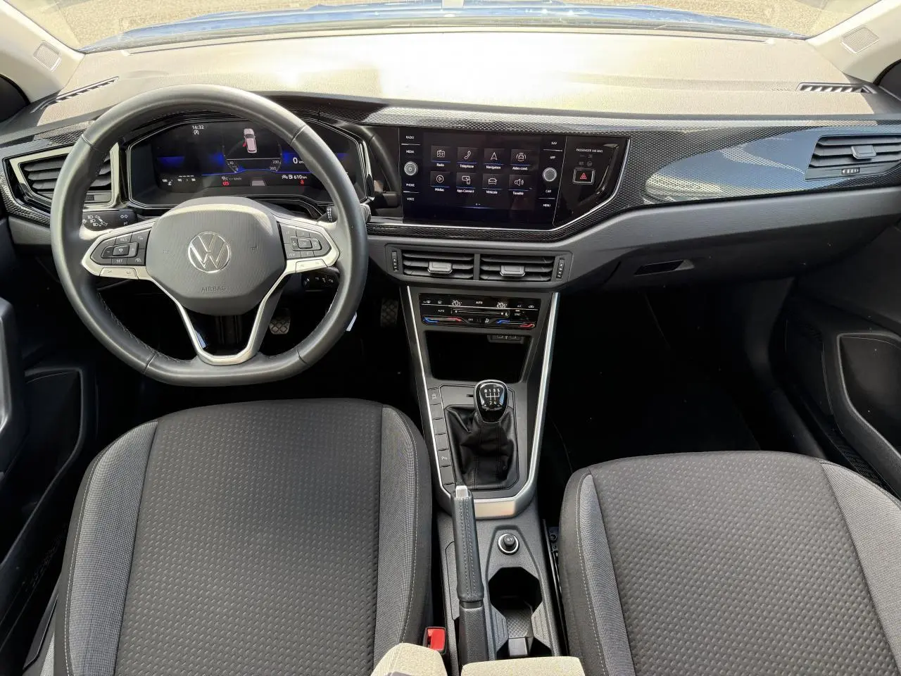 Intérieur du Volkswagen Taigo 2024 avec tableau de bord moderne, volant cuir multifonctions et boîte manuelle centrale.