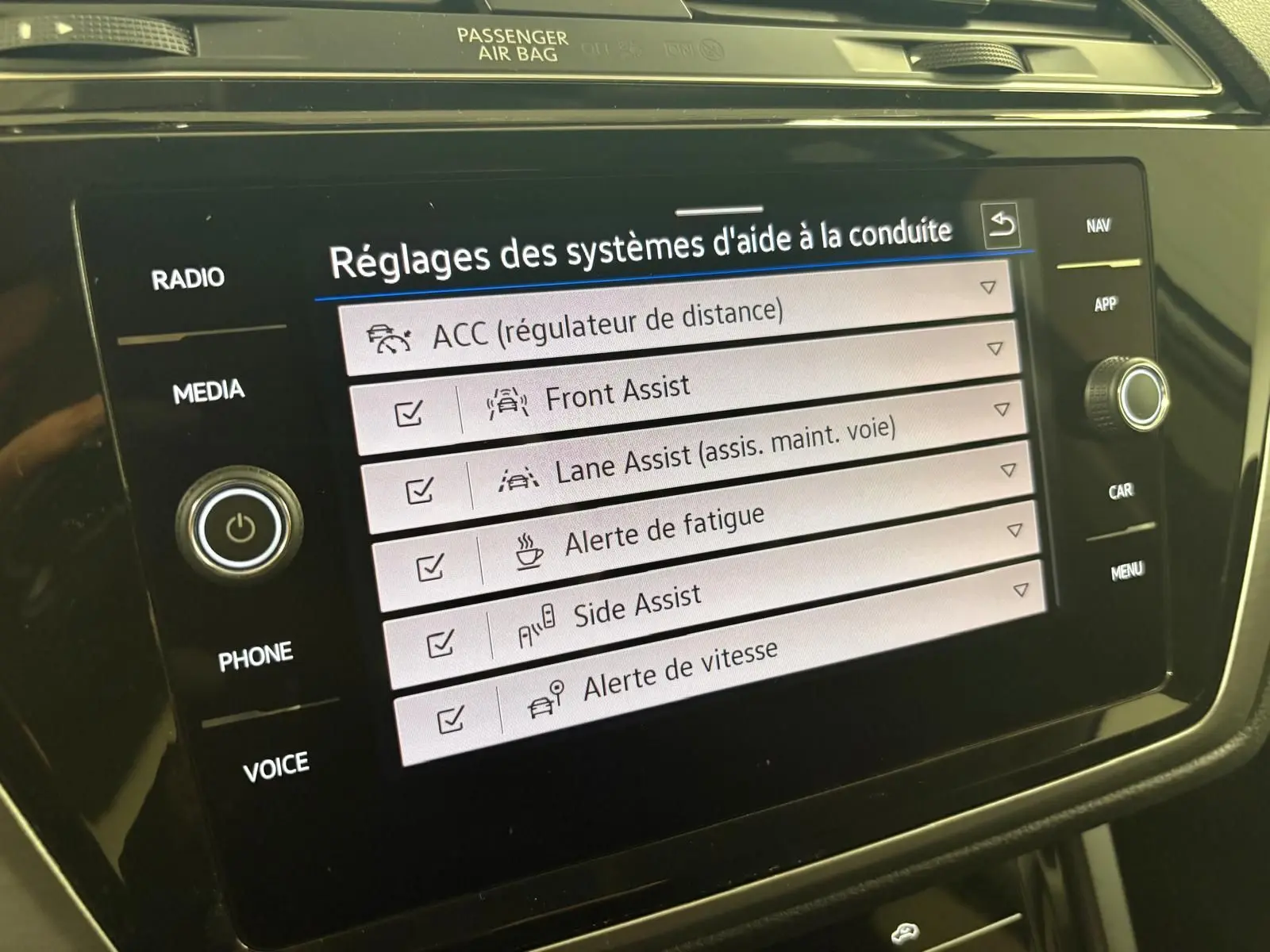 Écran tactile du système d'infodivertissement Volkswagen Touran 2024 affichant les réglages d'aide à la conduite.