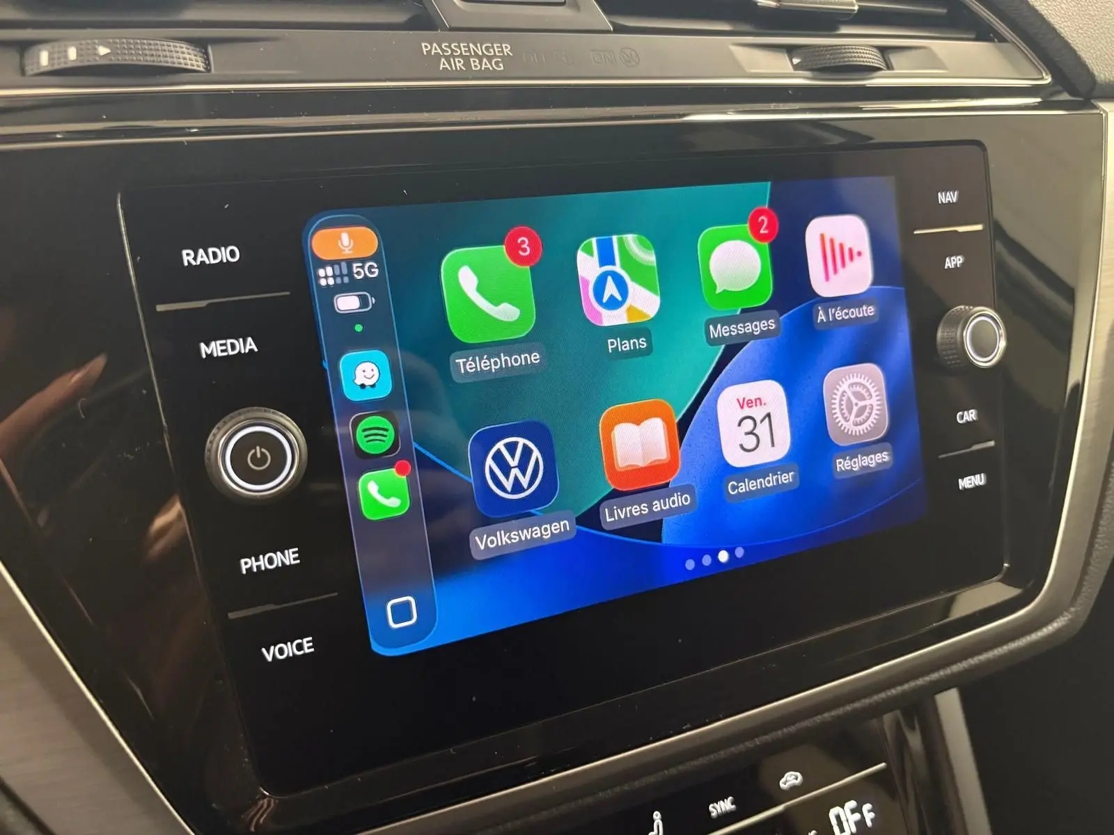 Écran tactile central du Volkswagen Touran 2024 affichant les applications connectées avec interface colorée et commandes tactiles.