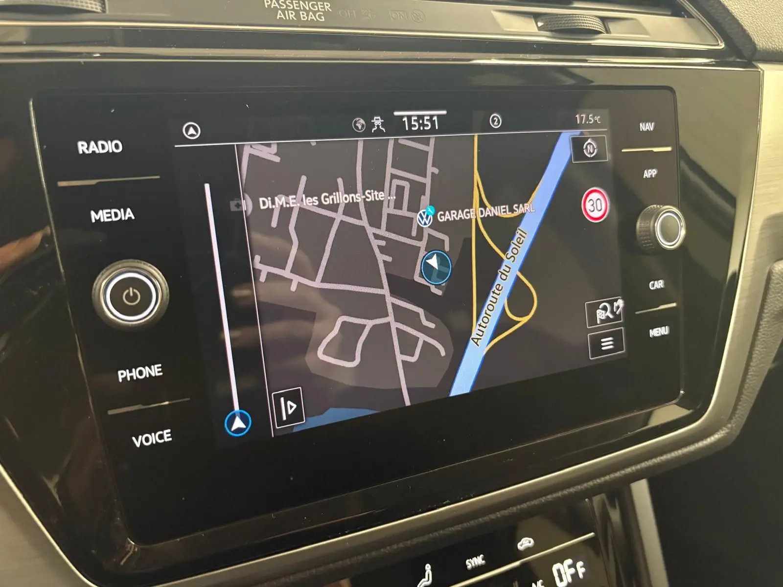 Écran tactile du système de navigation du Volkswagen Touran 2024 affichant une carte avec options multimédia et climatisation.