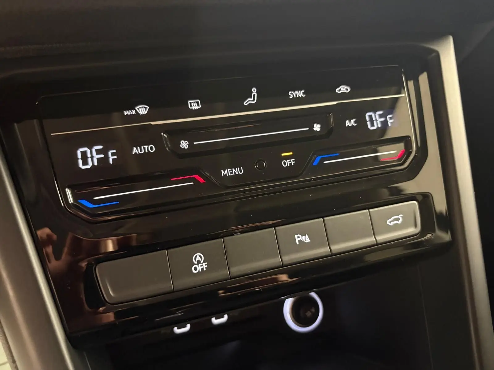 Panneau de commande de climatisation et boutons fonctionnels dans l'habitacle d'un Volkswagen Touran noir intense nacré.