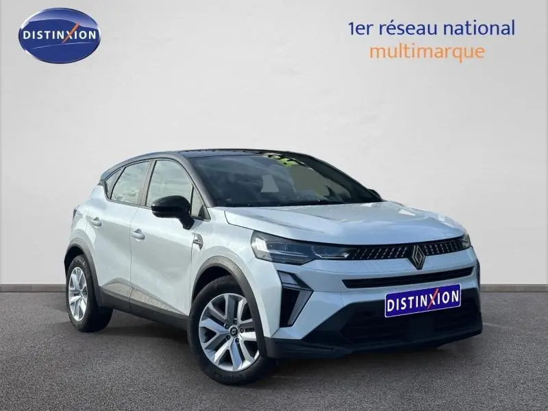 Vue 3/4 avant gauche d'un Renault Captur blanc nacré avec toit noir et jantes argentées sur fond neutre.