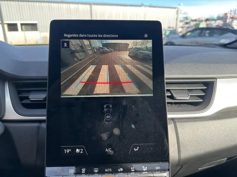 Vue intérieure du tableau de bord du Renault Captur 2025 avec écran tactile affichant la caméra de recul en marche.