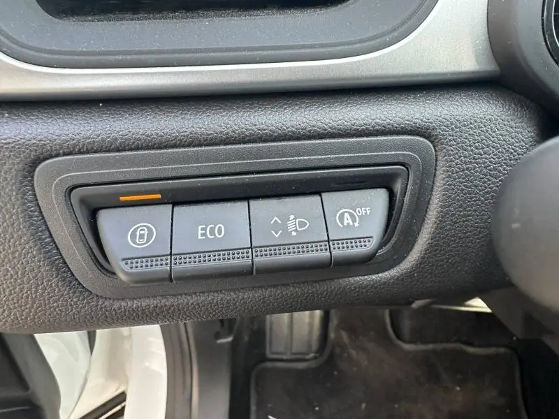 Gros plan sur les commandes ECO et verrouillage du tableau de bord d'un Renault Captur blanc nacré 2025.