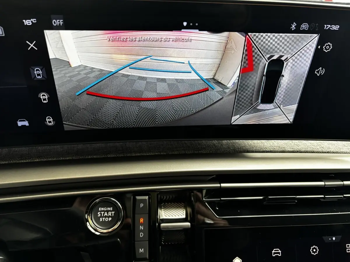 Vue intérieure du tableau de bord du Peugeot 3008 vert 2025, écran tactile affichant la caméra de recul et commandes de boîte auto.