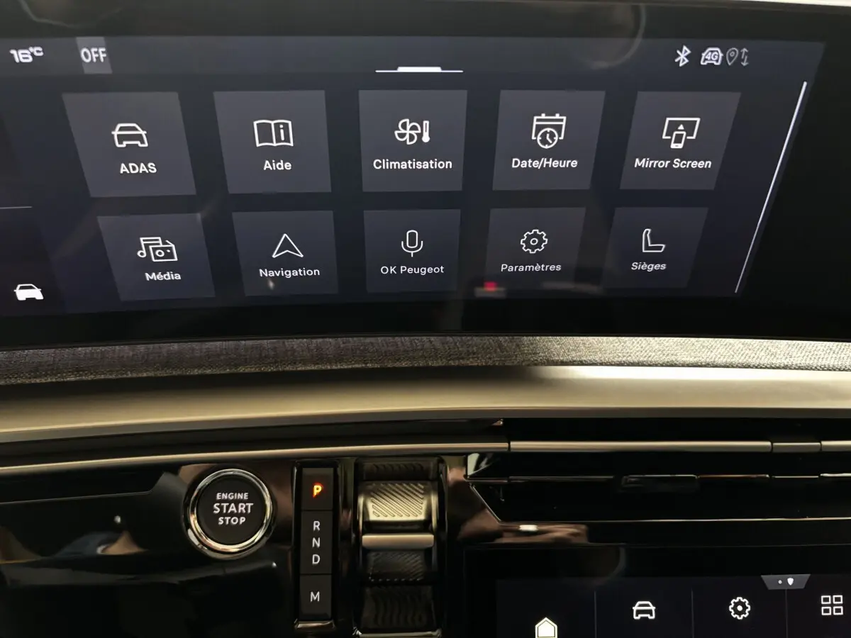 Vue rapprochée de l’écran tactile central et du bouton start/stop du tableau de bord du Peugeot 3008 vert 2025.